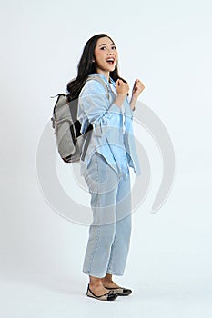 backview full leght shoot of happy asian Indonesian woman wearing casual attire and backpack on isolated background