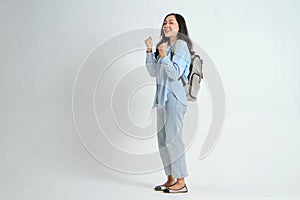 backview full leght shoot of happy asian Indonesian woman wearing casual attire and backpack on isolated background photo