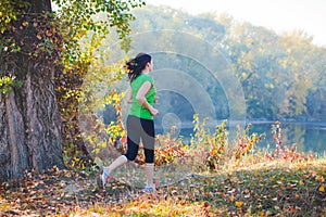 Backview of girl running in the city park