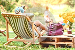 Backview of happiness woman on a summer holiday sitting on garden chair to relax