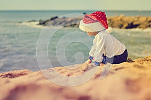 Backview of little kid in Santa hat on sunny