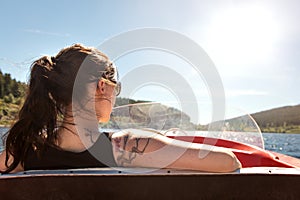 Backview from a woman in a boat, boating lake and blue sky