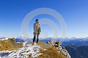 Backview of a woman hiker on the mountain top watching the Aips range photo