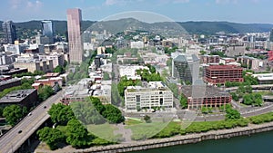 backwards flight above Willamette River with left panning - aerial cityscape view with buildings of Portland