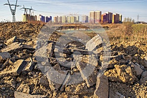 Backwoods with new high-rise buildings on the background of a dirty dump and pond