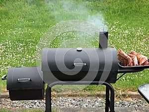 Backyard barbequing on a charcoal smoker