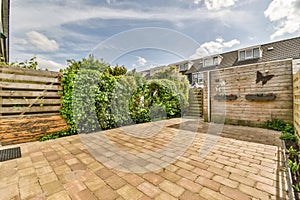 a backyard with a brick patio and a wooden fence