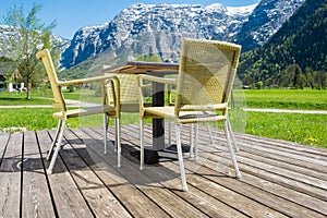 Backyard chair on wooden floor with mountains alps peaks background