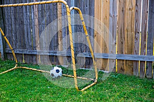 Backyard chldren soccer at the wood fence with wall
