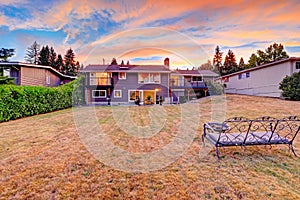 Backyard with cozy bench and fire pit overlooking scenic sky during sunset