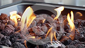 Backyard fire pit burning during summer evening. Close up view of flames of