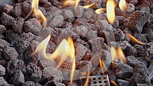 Backyard fire pit burning during summer evening. Close up view of flames of