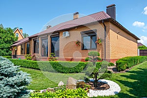 Backyard garden with nicely trimmed bonsai, bushes and bushes in front of villa