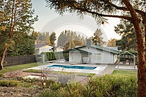 Backyard of a modern white house with a swimming pool. House outside the city. Space for text