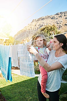 Backyard, mom and child hanging laundry together with help, teaching and learning chores. Housekeeping, mother and