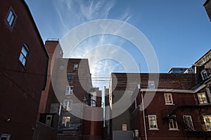 Backyard of some old, poor and dilapidated red brick buildings, of the vintage North American architectural style, in Montreal