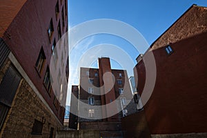 Backyard of some old, poor and dilapidated red brick buildings, of the vintage North American architectural style, in Montreal