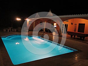 A backyard of a vacation house in dominican republic, blue pool and billiard.