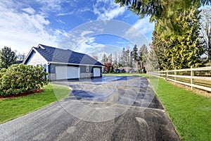 Backyard view of blue rambler home with attached garage