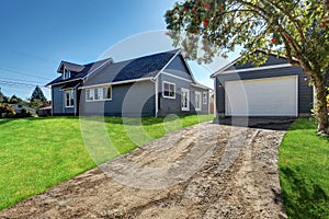 Backyard view of blue siding house with detached garage