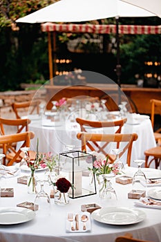 Backyard wedding reception - round tables with white tablecloths, vintage lanterns, roses and hyacinth,  and bentwood chairs