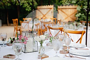 Backyard wedding reception - round tables with white tablecloths, vintage lanterns, roses and hyacinth,  and bentwood chairs