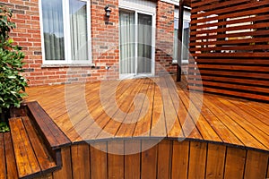 Backyard wooden deck floor boards with fresh brown stain