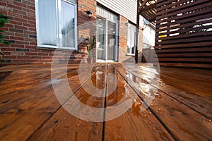 Backyard wooden deck floor boards with fresh brown stain