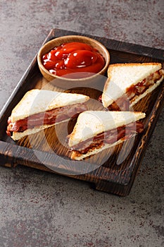 Bacon Butty  sandwich of fried bacon between bread that is optionally spread with butter, and may be seasoned with ketchup closeup