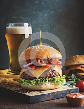 Bacon cheeseburger with red onion topping and lettuce salad