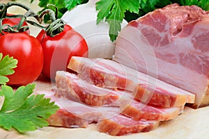 Bacon with cherry tomatoes,parsley and garlic on table