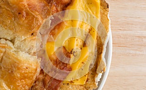 Bacon egg and cheese croissant breakfast sandwich on plate close