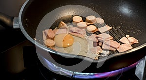 Bacon and egg in pan with fire