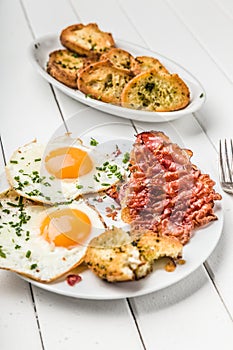 Bacon and eggs for breakfast with chives and bread