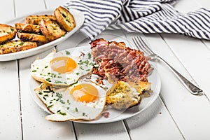 Bacon and eggs for breakfast with chives and bread