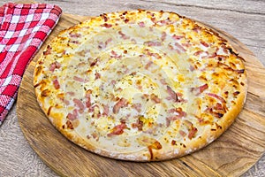 Bacon and potato pizz on a pizza board