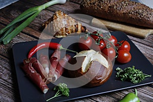 Bacon rolls with fresh vegetables and croissant on a kitchen table