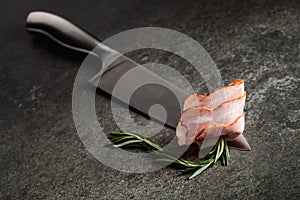 Bacon with rosemary on a kitchen knife