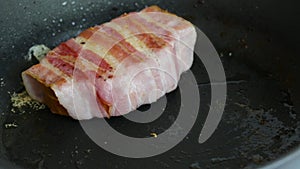 Bacon sandwich is fried in a frying pan.