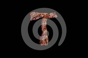 Bacon shaped as the word T on black background