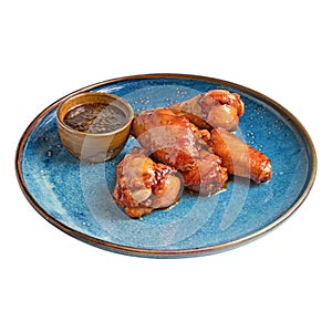 Bacon wrapped grilled chicken wings on plate over white background.