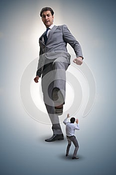 The bad angry boss kicking employee in business concept