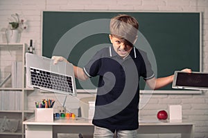 Bad boy student in opposition distance education. Angry kid broken online laptop at school. Smashing damaged computer