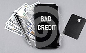 BAD CREDIT word on smartphone with credit card and pen