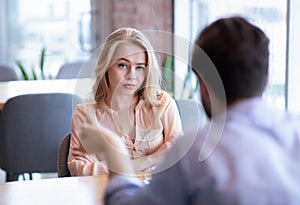 Bad date. Young woman feeling bored during dinner at cafe, unhappy with her boyfriend, disinterested in conversation