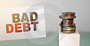 Bad Debt on a card and stack of coins. Business and financial problems concept, unpaid debts and bad credit history