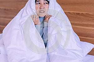 Bad dream or Nightmare,Asian woman with scared and panic while lying down under the blanket in bedroom