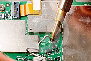 Bad electrical circuit being repaired by a technician with a tin soldering iron