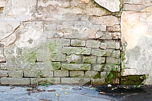 Bad foundation base on old house or building cracked plaster facade wall with brick background