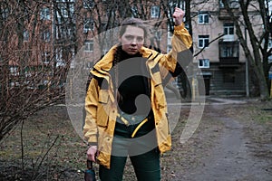 Bad girl bully in yellow coat in the backyard. Outdoor lifestyle portrait